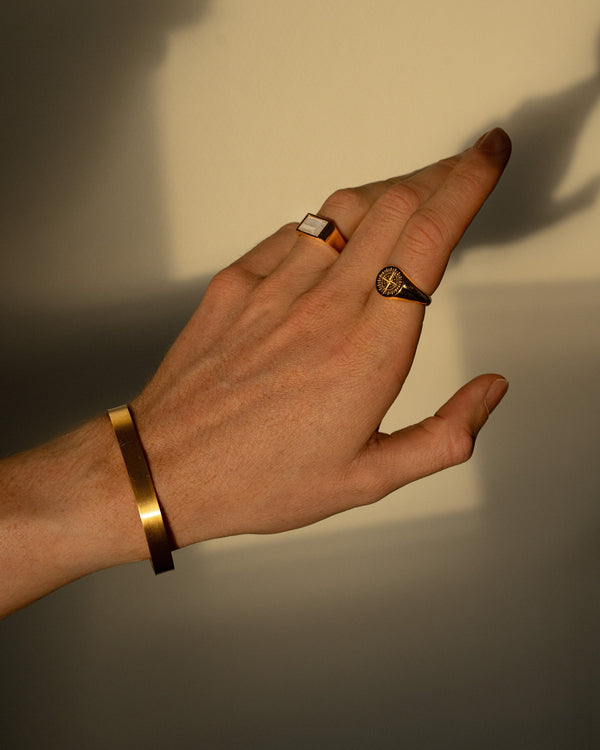 Schmuck Set fuer Maenner in Gold Vermeil mit eckigem blauem Achat Siegelring und Kompass Siegelring aus 925 Sterling Silber kombiniert mit matt gebuerstetem Edelstahl Armreif getragen als ausdrucksstarker moderner Lifestyle Look Sprezzi Fashion
