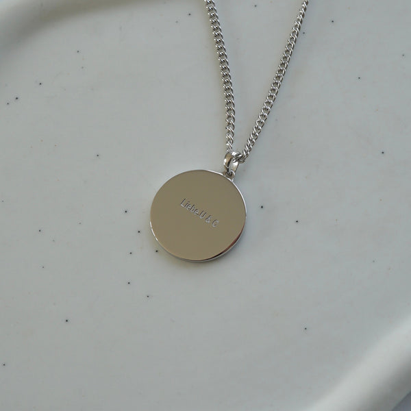 Silberne Halskette mit rundem Anhänger und eingraviertem Text zeigt personalisierte Gravur auf Schmuckstück als individuelles Geschenk mit emotionaler Bedeutung Sprezzi Fashion