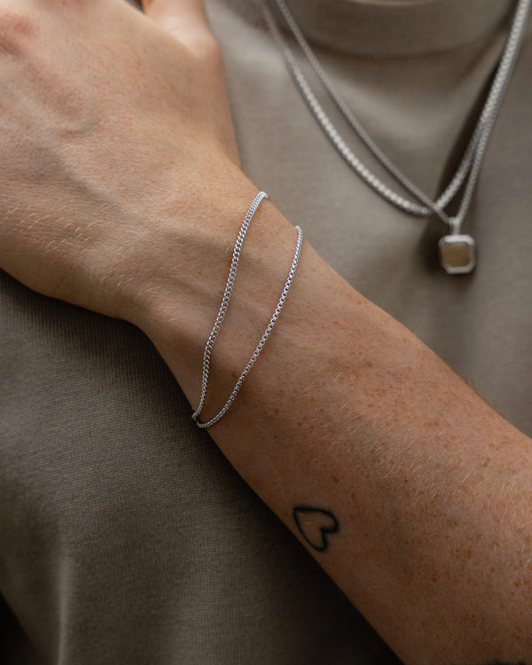 Armband Set aus 925 Sterling Silber mit feinem Box Thin Armband und schmalem Small Curb Panzer Armband getragen am Handgelenk fuer einen klaren minimalistischen Look mit reduzierter Eleganz moderner Linienfuehrung und maskuliner Ruhe im Alltag Sprezzi Fashion