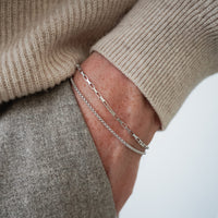 Minimalistisches Silberarmband Herren aus 925 Sterling Silber im Box Thin und Small Paperclip Design, gemeinsam am Handgelenk getragen, wobei die unterschiedlichen Gliederstrukturen stilvoll kombiniert werden Sprezzi Fashion