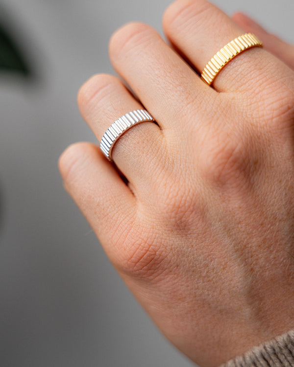 Herren Ring Set aus 925 Sterling Silber mit zwei schmalen Linear Bandringen in Silber und Gold Vermeil getragen an der Hand fuer einen ausdrucksstarken Look mit praeziser Linienfuehrung geriffelter Oberflaeche und moderner maskuliner Klarheit Sprezzi Fashion