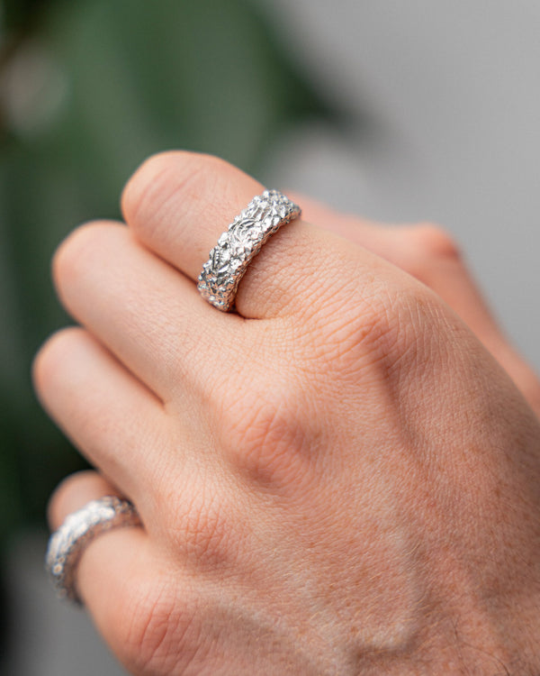 Nell'immagine indossata, l'anello appare distintivo e minimalista grazie alla superficie modellata in modo simile a un meteorite e alla forma moderna Sprezzi Fashion