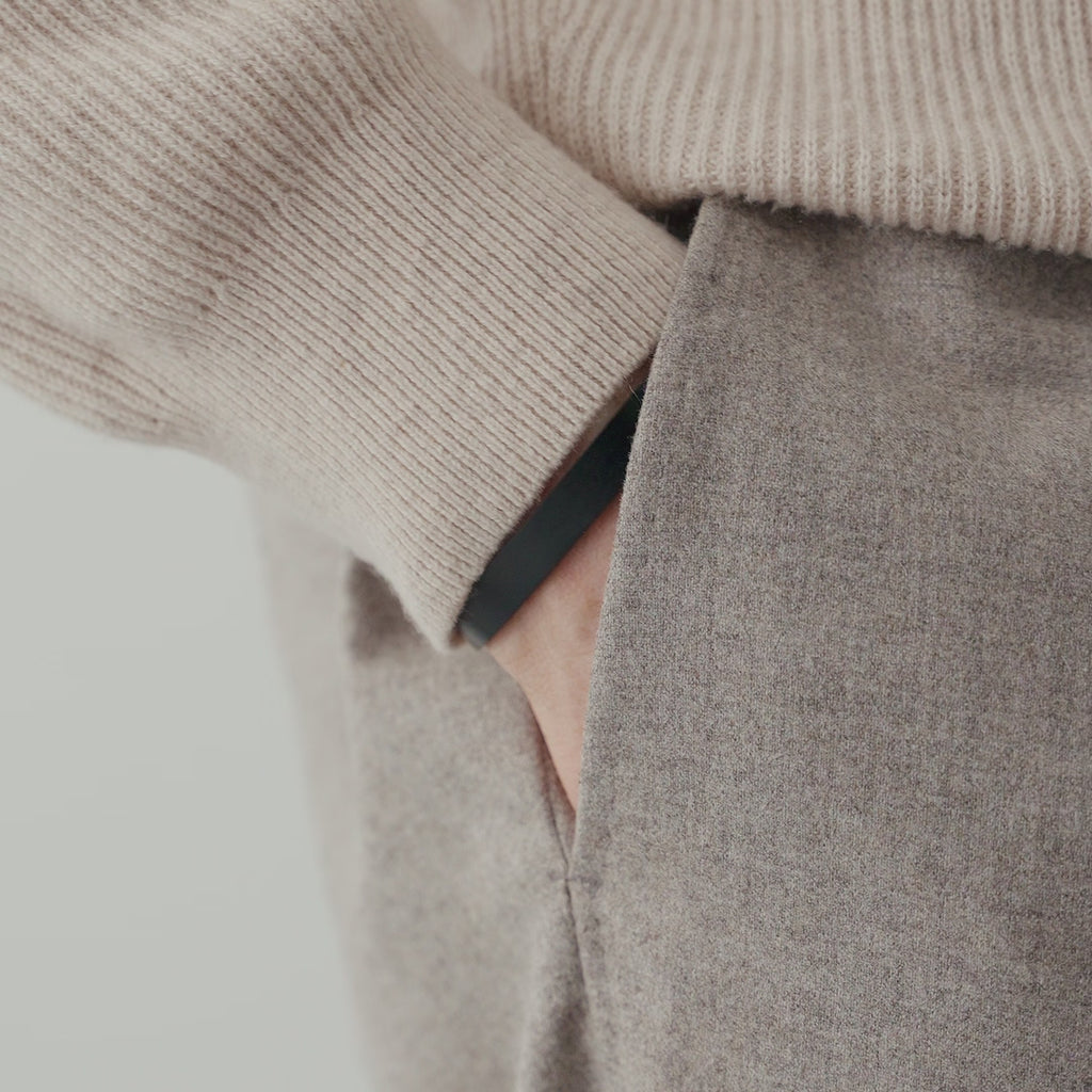 Schwarzer Herren Armreif aus Edelstahl mit matter Oberfläche, getragen am Handgelenk in Kombination mit Strickstoff und Mantel, wodurch ein moderner und maskuliner Look mit klaren Linien entsteht Sprezzi Fashion