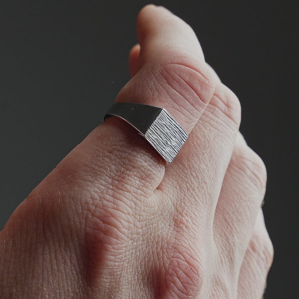 Produktvideo zeigt einen Herren Ring aus 925 Sterling Silber in eckiger Form mit deutlich sichtbarer Raw Gravur Sprezzi Fashion