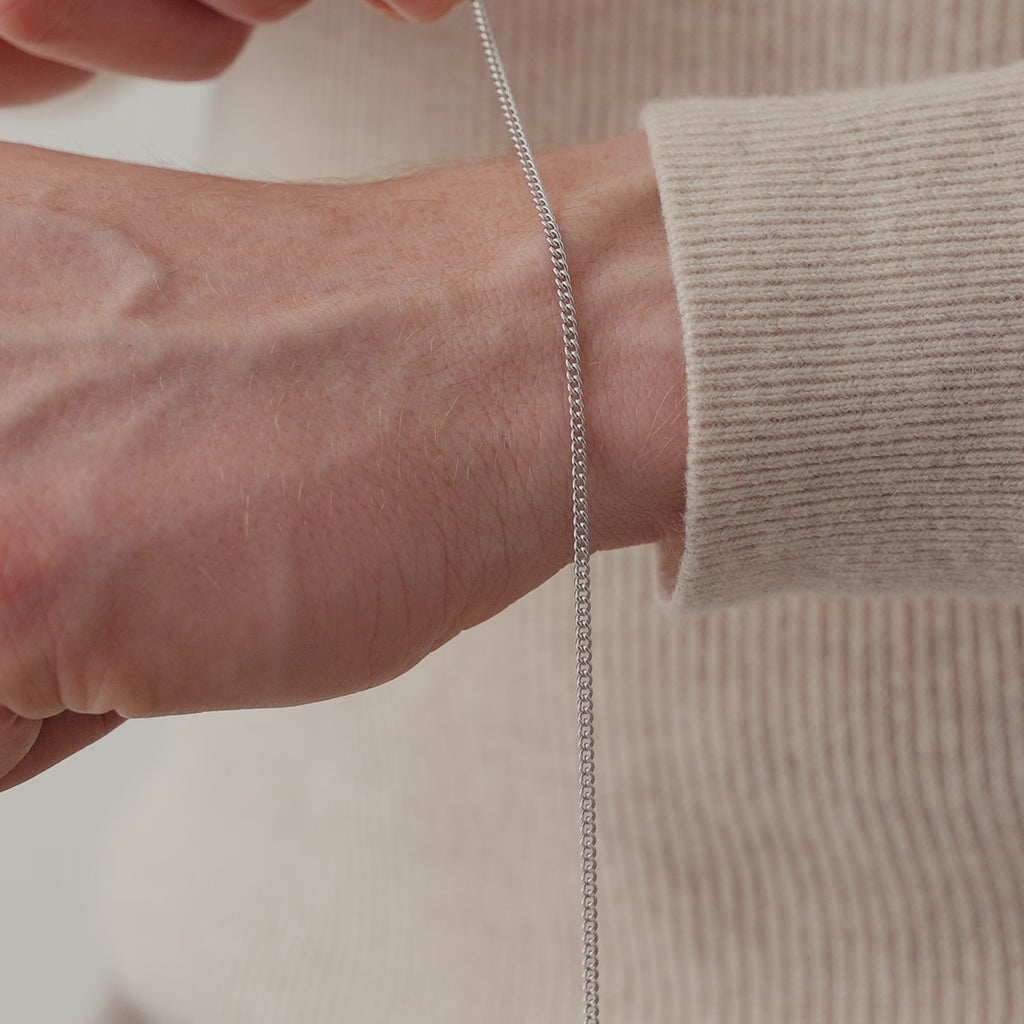 Nahaufnahme eines Herren Armbands aus 925 Sterling Silber mit schmalen Panzer Gliedern, das leicht am Handgelenk liegt und eine klare, gleichmäßige Struktur zeigt Sprezzi Fashion